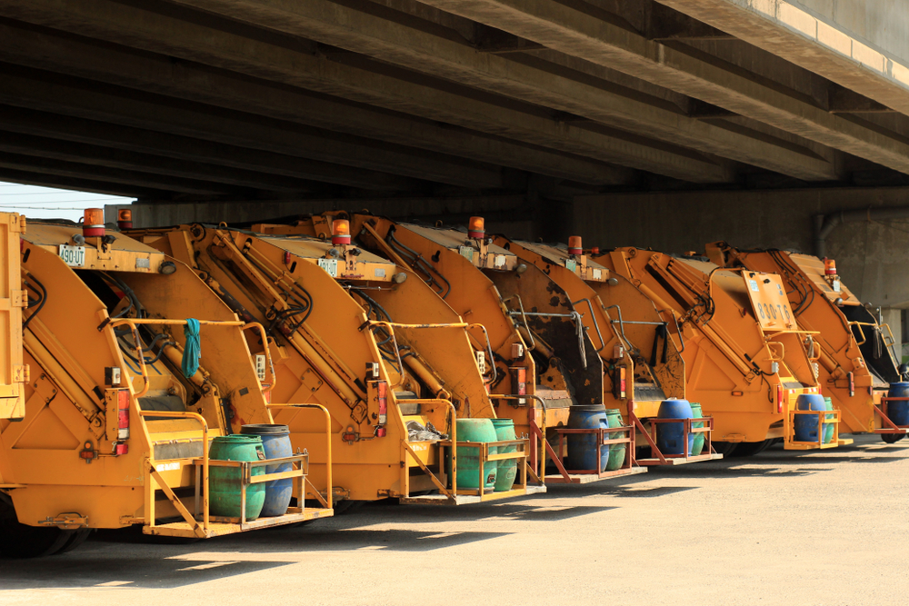 a,photo,of,a,row,of,yellow,municipal,garbage,trucks