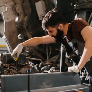 professional,mechanic,inspecting,engine,oil,in,a,truck,,performing,routine