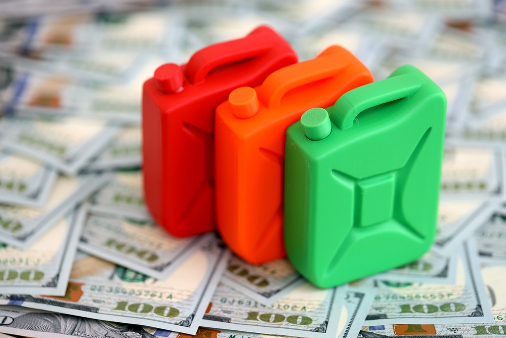 gasoline,canister,lies,on,big,amount,of,dollar,bills.,concept