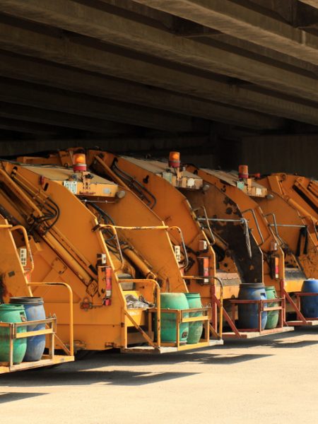 a,photo,of,a,row,of,yellow,municipal,garbage,trucks